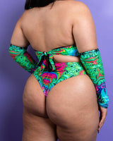 Rear view of a model in a vibrant printed halter top and matching bottoms, showcasing a stylish rave outfit.