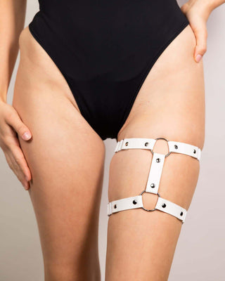 White leather adjustable leg garter displayed on a model, perfect for edgy rave outfits and festival fashion.