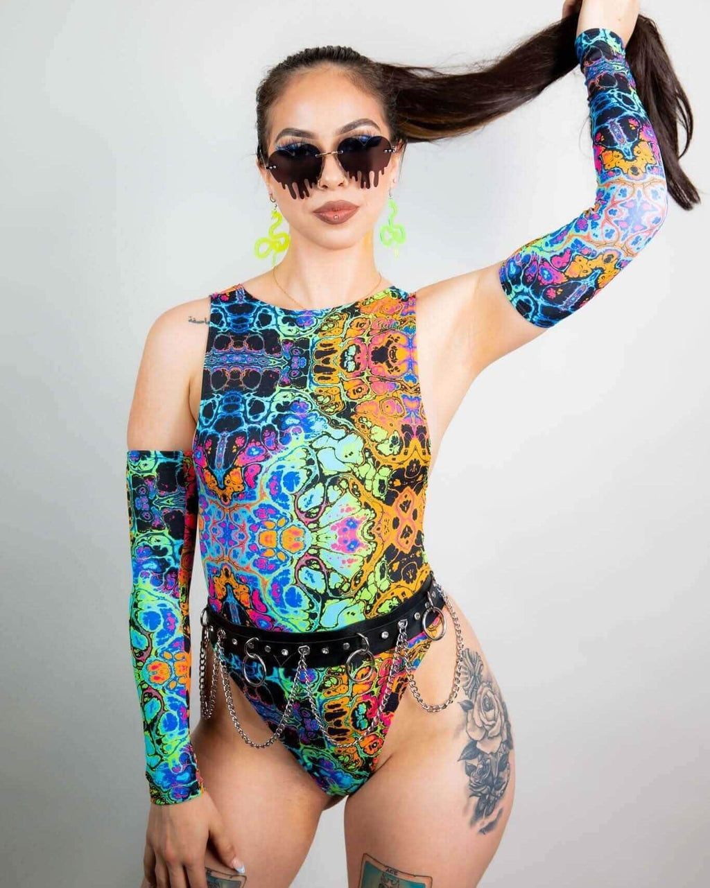 Model showcasing psychedelic rainbow arm sleeves with a colorful bodysuit, perfect for rave outfits.