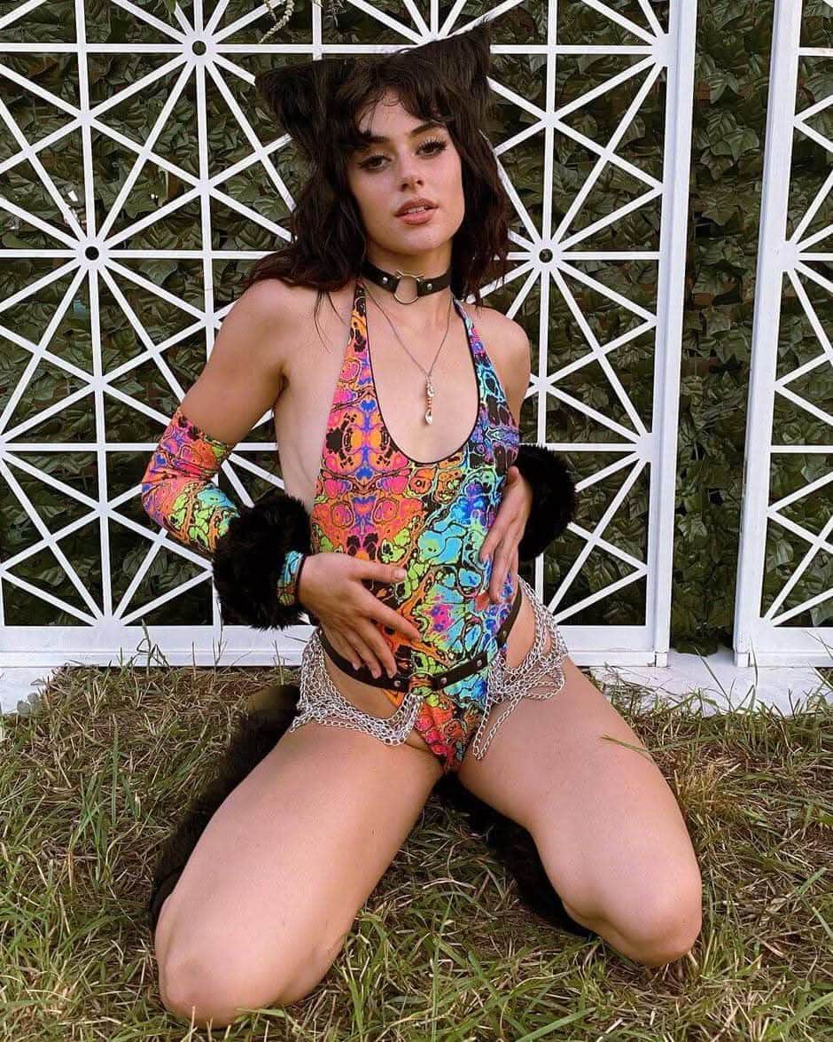 Model in colorful Lucidity Temptation Cheeky One Piece, showcasing a psychedelic rainbow design perfect for rave outfits.