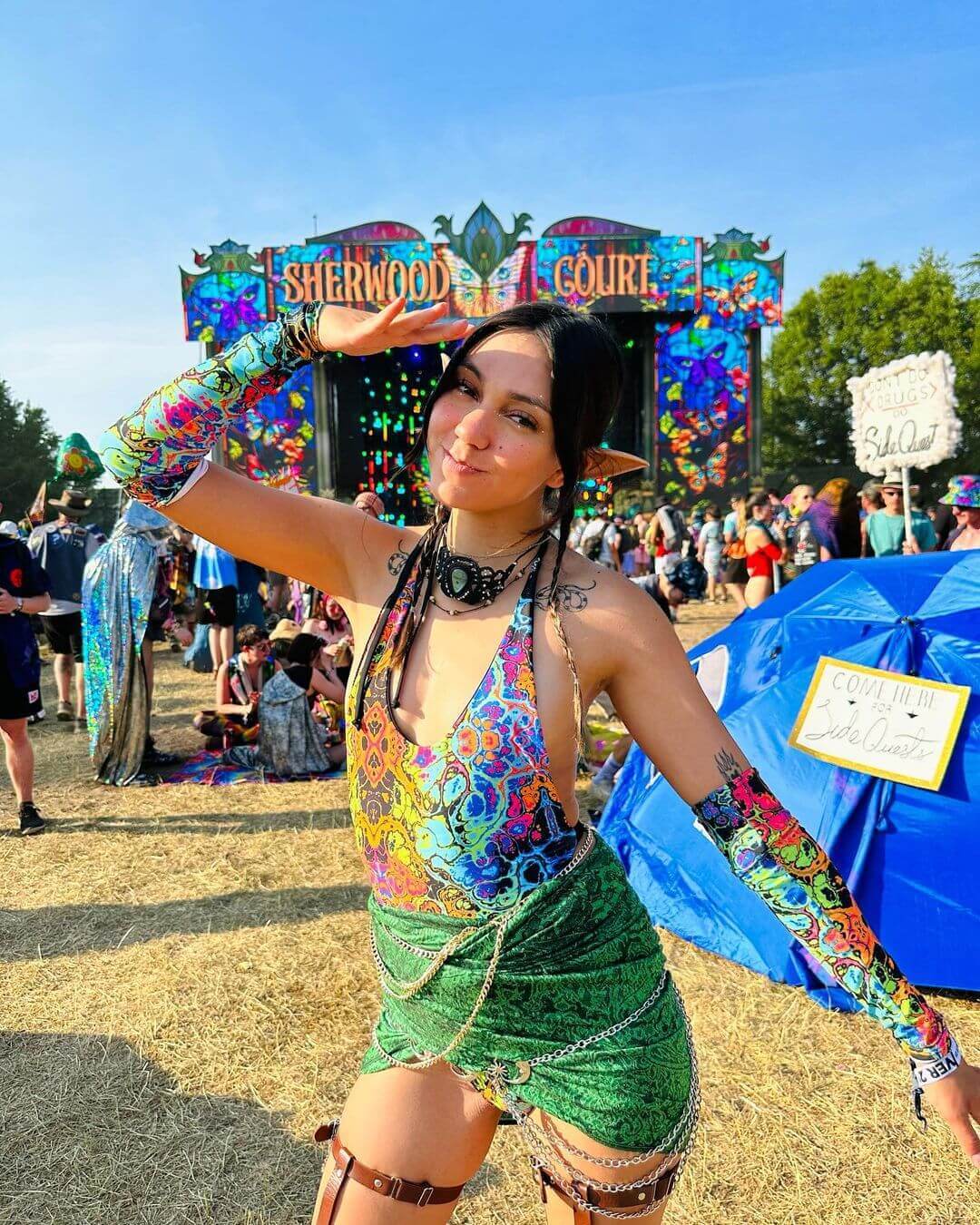 Festival-goer in rainbow rave outfit posing at Sherwood Court, showcasing vibrant festival style and energy.