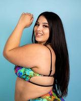 Model showcasing the Lucidity Wonder Top with vibrant psychedelic rainbow design against a light blue background.