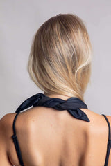 Matte black bandana tied around a woman's neck, showcasing a chic look for rave outfits and festivals.