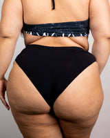 High-waisted matte black Brazilian bottoms showcasing a cheeky cut, perfect for rave outfits and summer fun.