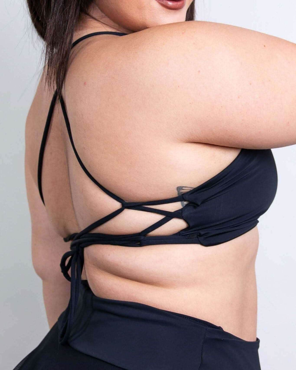 Matte black lace-up back top, perfect for rave outfits, showcasing stylish design and great support.