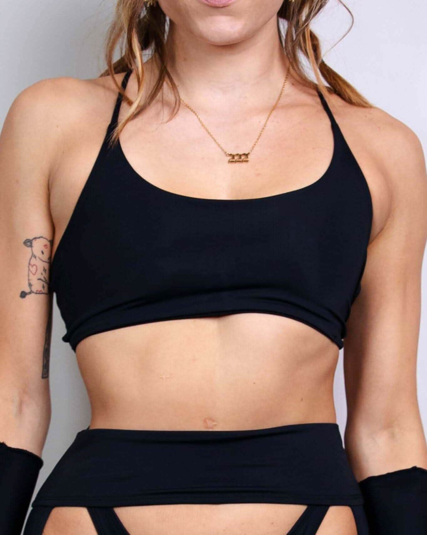 Model showcasing the Matte Black Lush top, perfect for rave outfits with a sleek design and lace-up back detail.