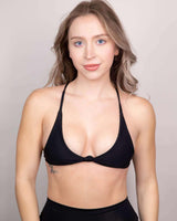 Model wearing the Matte Black Serendipity Top, a supportive eco-friendly bikini ideal for beach and pool outings.