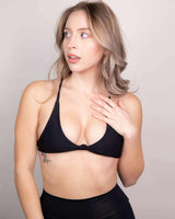Model showcasing the eco-friendly Matte Black Serendipity Top, a supportive bikini top ideal for beach and pool outings.