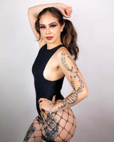 Model wearing a matte black sideboob bodysuit with fishnet stockings, ready for a rave outfit.