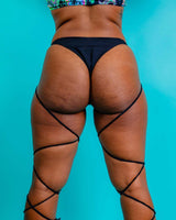 Matte black strappy high hip bottoms displayed from behind, perfect for rave outfits and trendy summer looks.