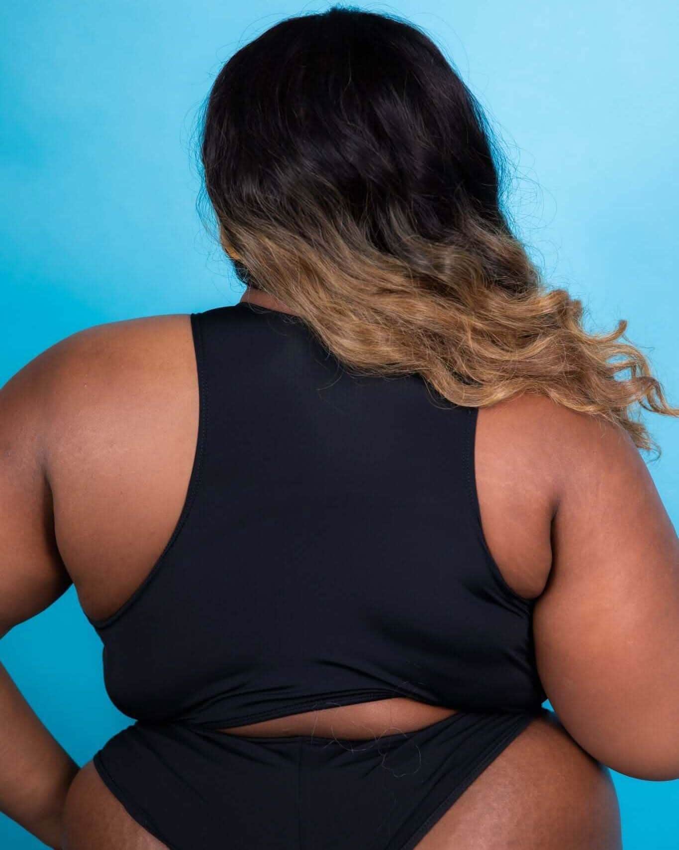 Matte black racerback teaser top worn from the back, showcasing its stylish cut, perfect for rave outfits.