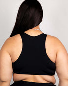 Matte black teaser top for women, showcasing racerback design and underboob cut, perfect for rave outfits.