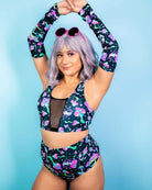 Model showcasing Mushies arm sleeves and matching rave outfit with a playful design against a blue background.