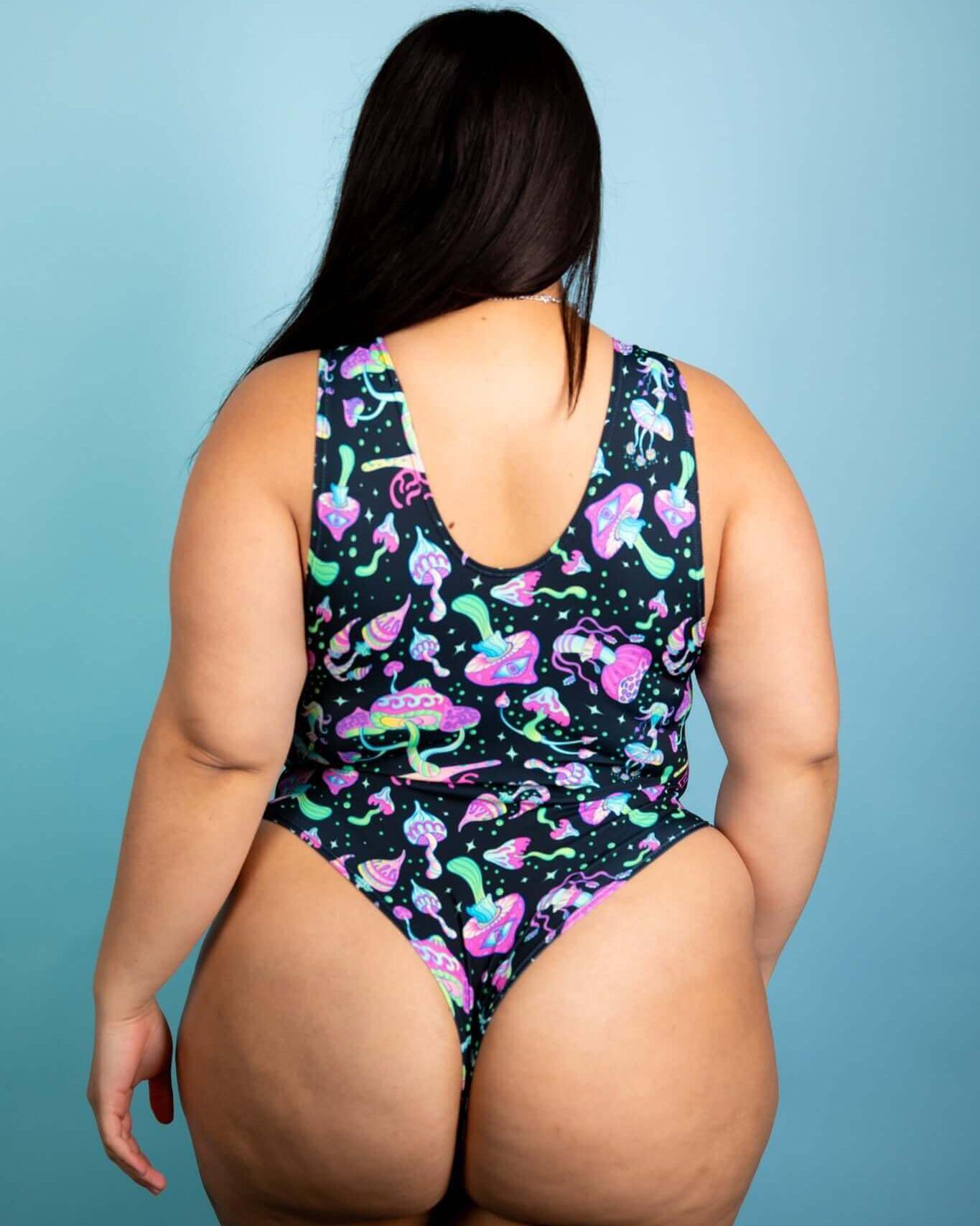 Back view of plus-size individual wearing a psychedelic mushroom bodysuit, perfect for rave outfits and festivals.