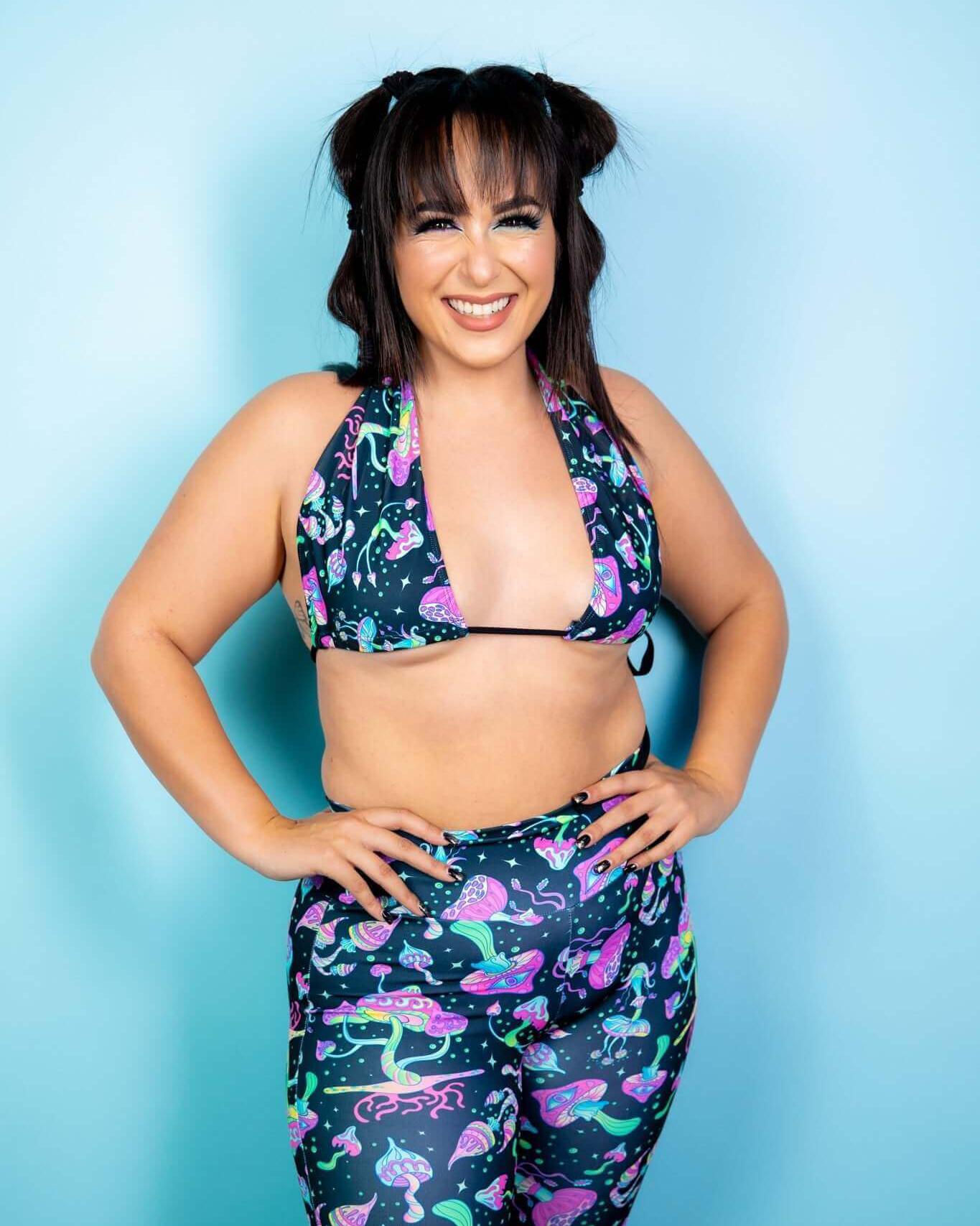 Model wearing the Mushies twist tie bandeau top, featuring a vibrant mushroom print, perfect for rave outfits.