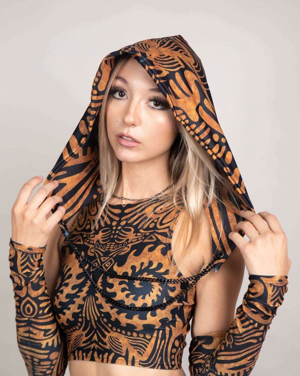 Model wearing Primal Assassin Hood, a unique rave outfit featuring bold tribal patterns, perfect for festival fun.