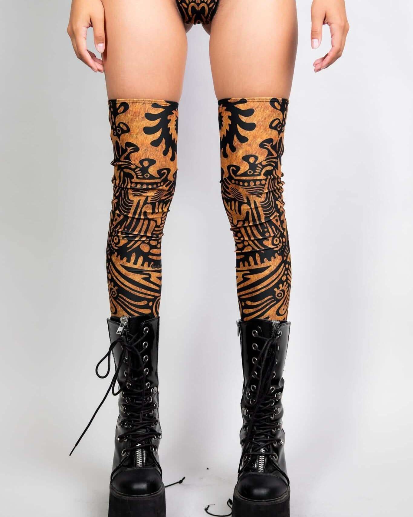 Primal Leg Sleeves in tribal design, paired with chunky black lace-up boots, perfect for rave outfits.