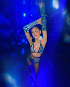 Model wearing Duality rave arm sleeves with geometric black white pattern dancing under blue festival lights
