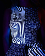 Duality rave bodysuit with black white geometric patterns and sideboob cutouts under UV lighting side view