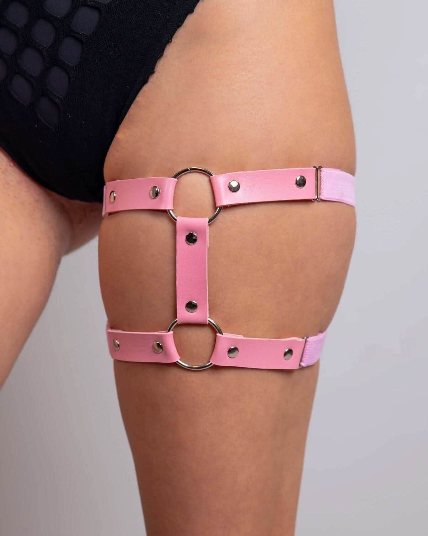 Light pink leather adjustable leg garter with metal rings worn with rave bodysuit festival outfit side view