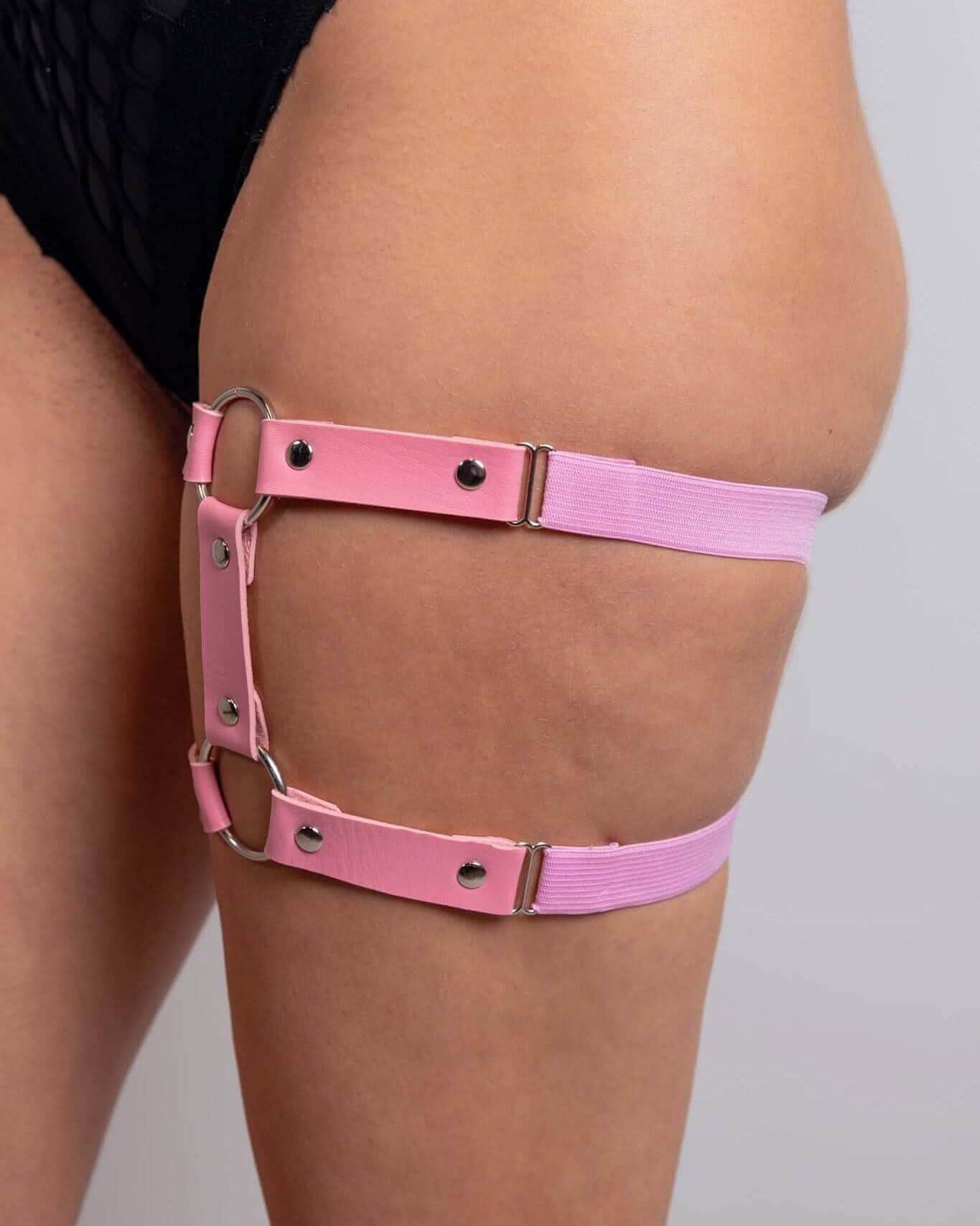 Light pink leather adjustable leg garter rave bodysuit accessory worn on thigh with metal hardware side view