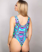 Sugar Rush rave bodysuit back view showing psychedelic swirl pattern in turquoise pink purple on blonde model