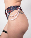 White chain accessory styled with rave bodysuit bottoms featuring cut-out hip details and marble print for festival fashion