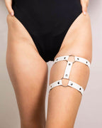 White leather adjustable leg garter worn with black rave bodysuit festival outfit detail shot