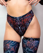 Model wearing Darkness high-waisted rave pants with ornate pattern, front view festival outfit styling