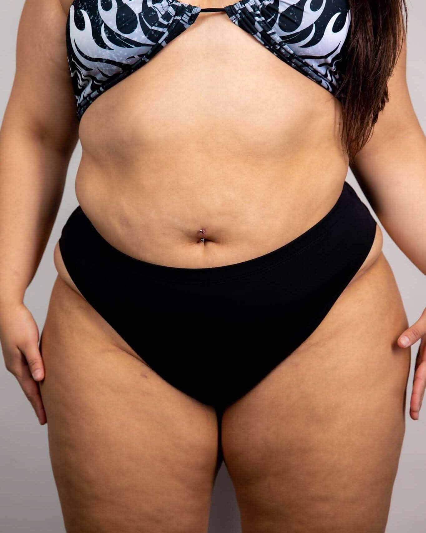 Matte black high waisted rave pants bottoms styled with patterned top, front view festival outfit