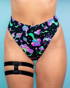 Mushies high waisted rave pants with neon mushroom print and leg harness straps festival outfit front view