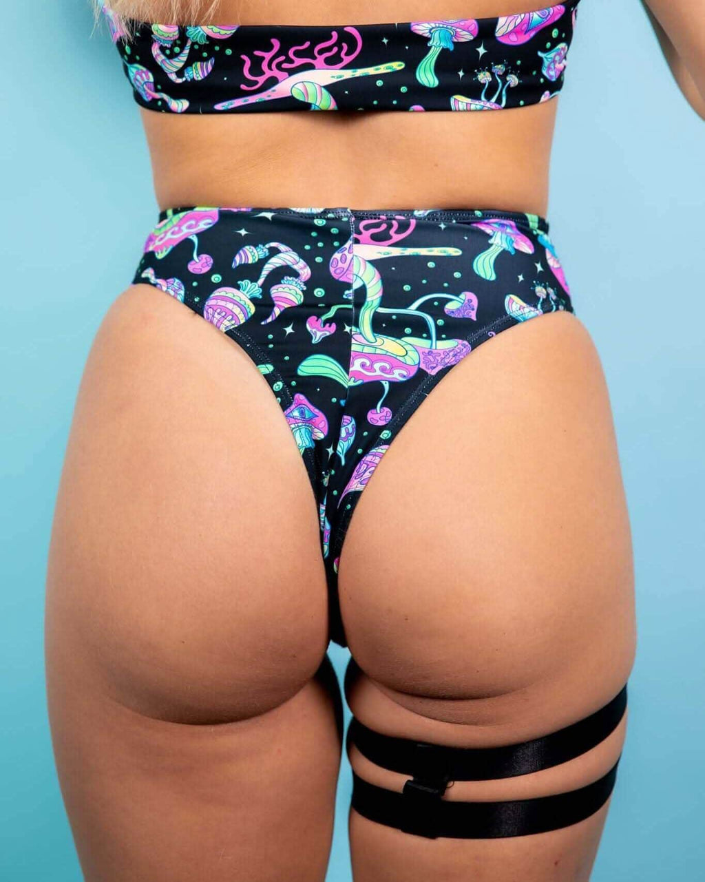Back view of Mushies high-waisted rave pants with psychedelic mushroom print and thigh straps for festival outfit styling