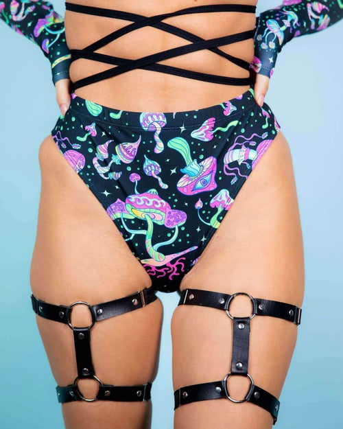 Mushies high waisted rave pants with psychedelic mushroom print and black leg harnesses festival outfit front view