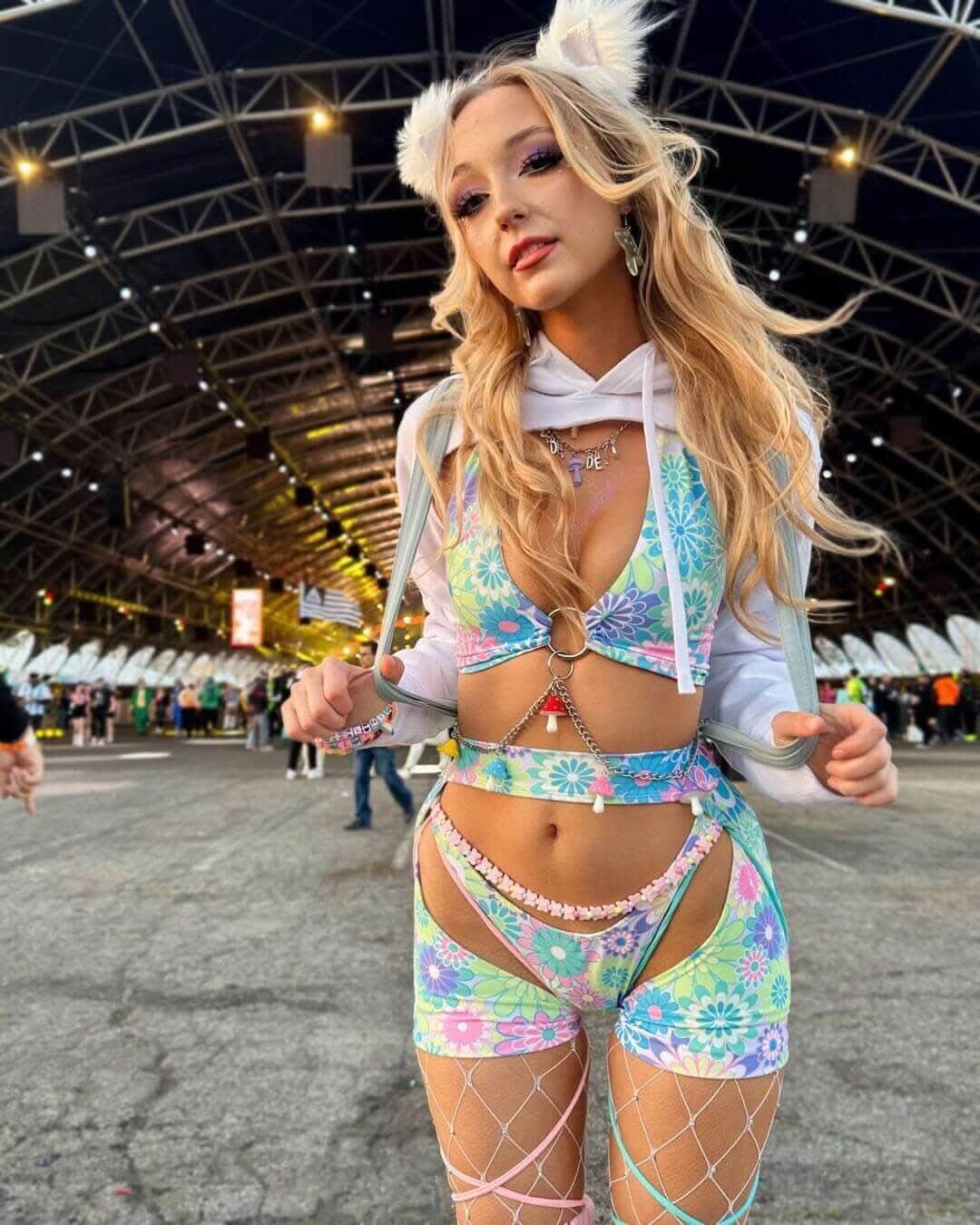 Model wearing Retro Bloom strappy rave pants with vibrant floral print at festival venue