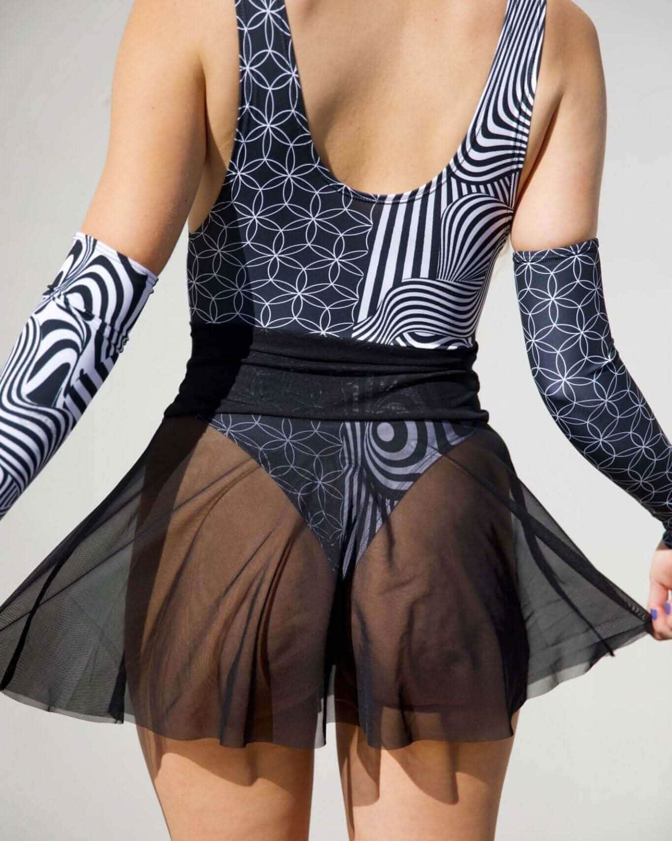 Black mesh rave skirt worn over geometric bodysuit, front view festival outfit styling