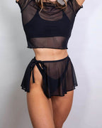 Black mesh swirl rave skirt styled with matching crop top in frontal pose on model