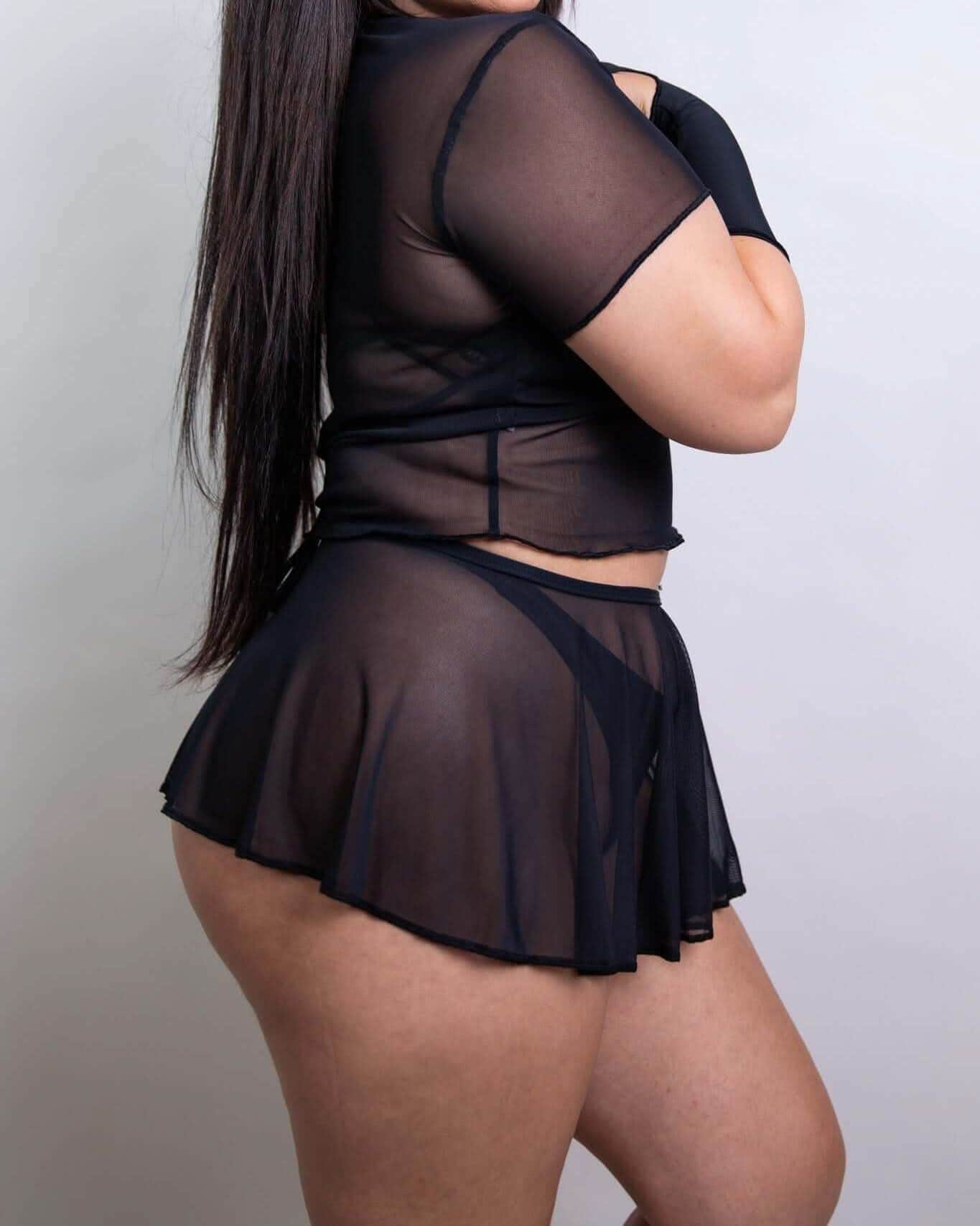 Black mesh swirl rave skirt worn by model from side angle showing festival outfit styling and fit