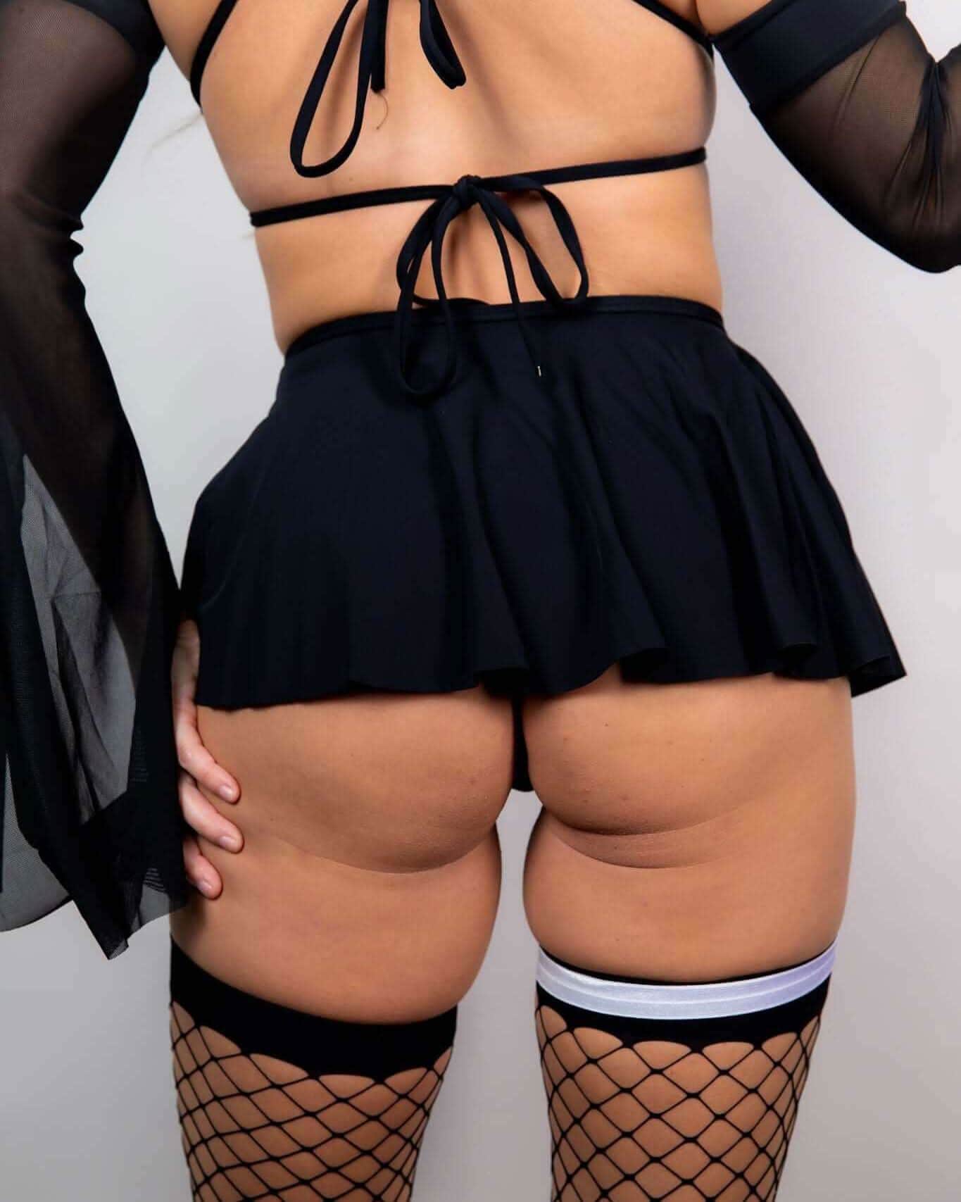 Back view of black matte rave skirt with tie waist styling for festival outfits and EDM events
