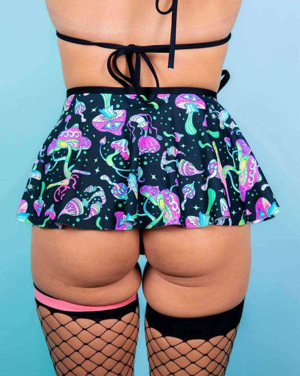 Back view of Mushies rave skirt with colorful mushroom print and ruffle hem for festival outfit styling