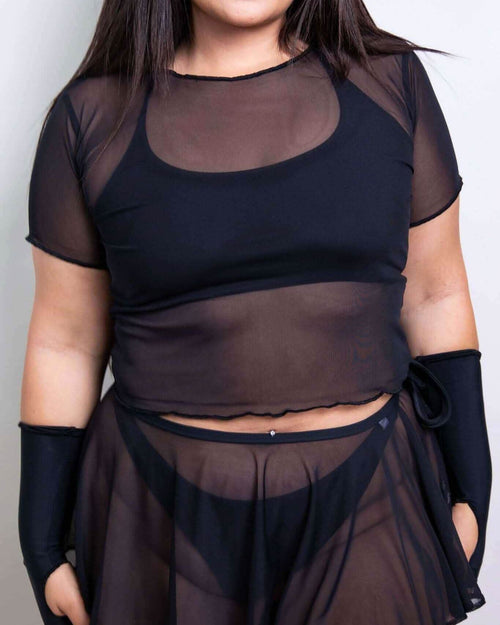 Black mesh rave top with short sleeves styled as festival outfit on model front view