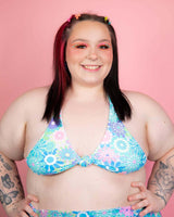 Model wearing a pastel floral halter top, showcasing vibrant colors perfect for rave outfits.