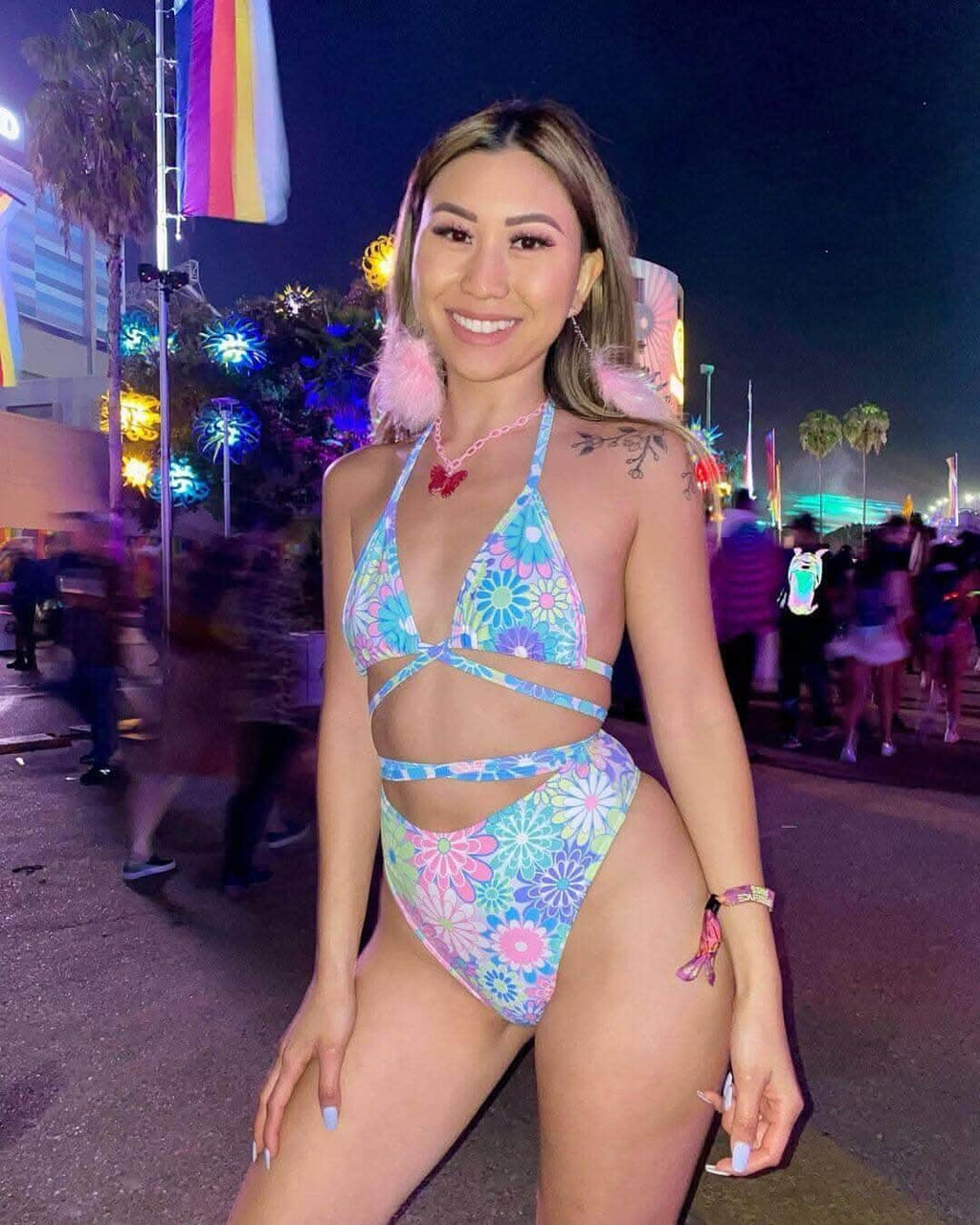 Model in Retro Bloom Wrap Bikini Top at a festival, showcasing pastel floral print and creative tying for rave outfits.
