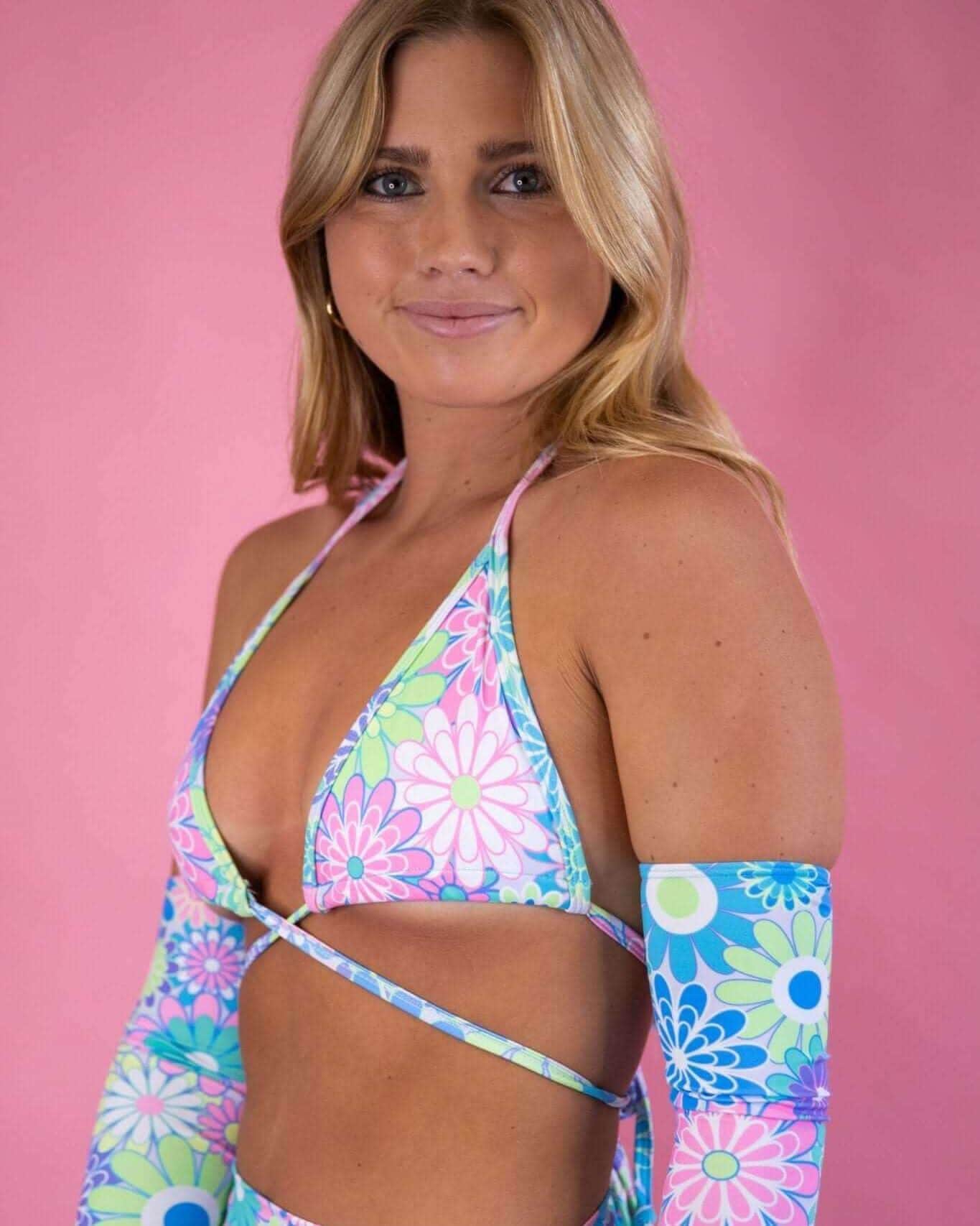 Model showcasing the Retro Bloom Wrap Bikini Top with pastel flower print, perfect for summer rave outfits.