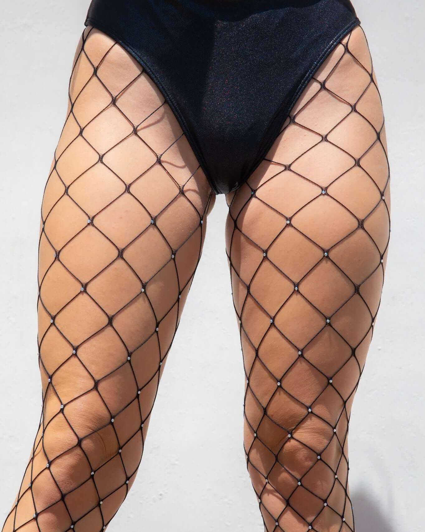 Black rhinestone fishnet stockings highlighting legs, perfect for rave outfits and festivals, made from spandex.
