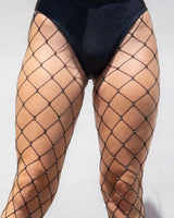 Black rhinestone fishnet stockings highlighting legs, perfect for rave outfits and festivals, made from spandex.