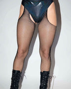 Black fishnet stockings with rhinestones paired with high-waisted shiny shorts and combat boots, perfect for rave outfits.