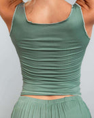 Woman wearing a soft ribbed green lounge tank top, showcasing a relaxed fit and comfortable design, perfect for rave outfits.