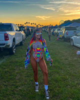 Model wearing Technicolor Sideboob Bodysuit at a festival, showcasing vibrant psychedelic print and rave outfit style.