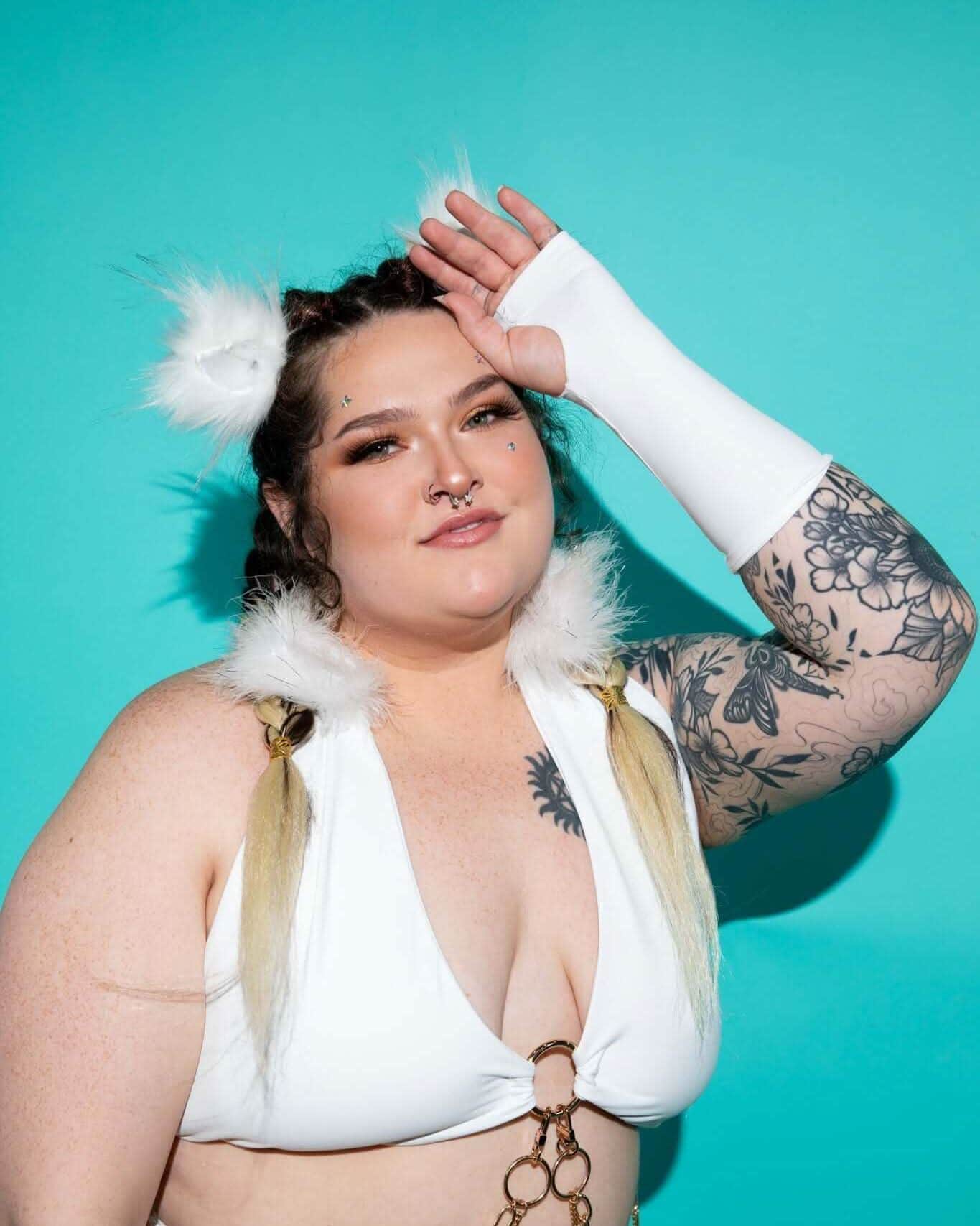 Model showcasing White Eco-Luxe Gloves with rave outfit against a vibrant teal background.