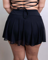 Women's matte black mesh skort with attached shorts, perfect for rave outfits, showcasing a stylish back view.